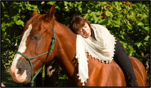 Woman in white shawl lying on horse