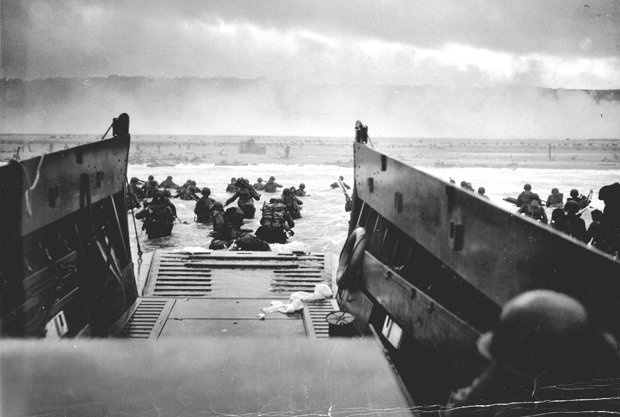 Soldiers leaving a boat and in the water of Omaha Beach, Normandy, during World War II.